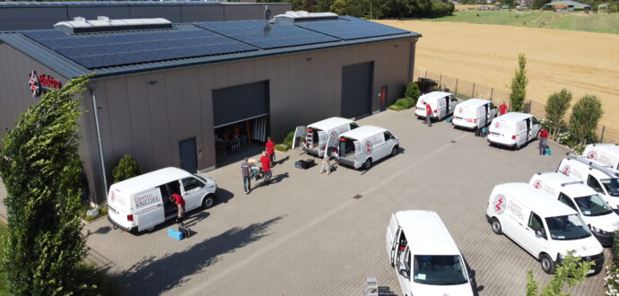 Firmengeländer der Elektro Knedel GmbH mit PV-Anlage und Elektroniker zum Arbeitsbeginn am Kundendienstfahrzeug
